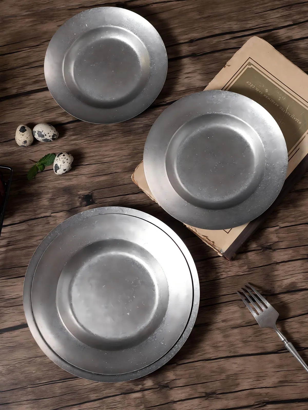 Snowflake-gray stainless steel plates arranged on a wood table